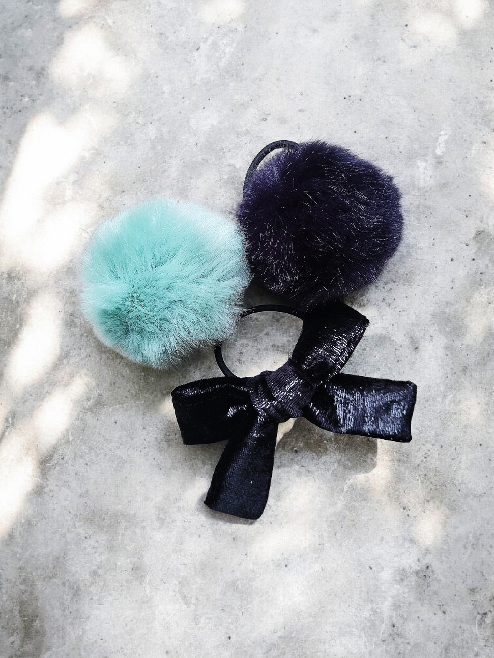 Faux Fur Pom Pom Set With Velvet Hair Bow Hair accessory set: Two colorful faux fur pom pom hair band (light green and navy blue) and one black velvet bow with shimmer.