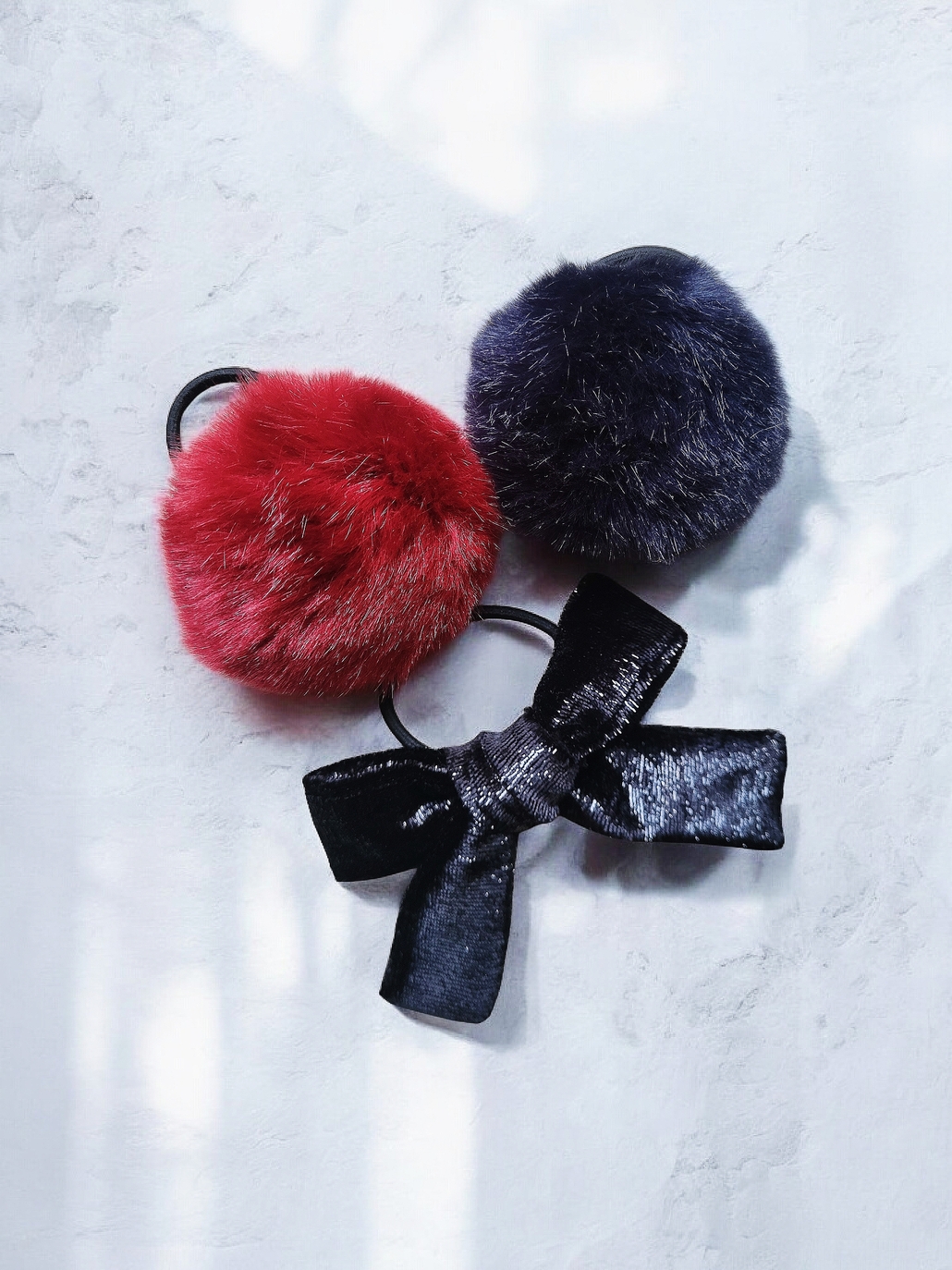 Faux Tur Pom Pom Red Blue Black Hair Bow Hair accessory set: Two colorful faux fur pom pom hair ties (dark red, dark blue) and one black velvet bow with shimmer.