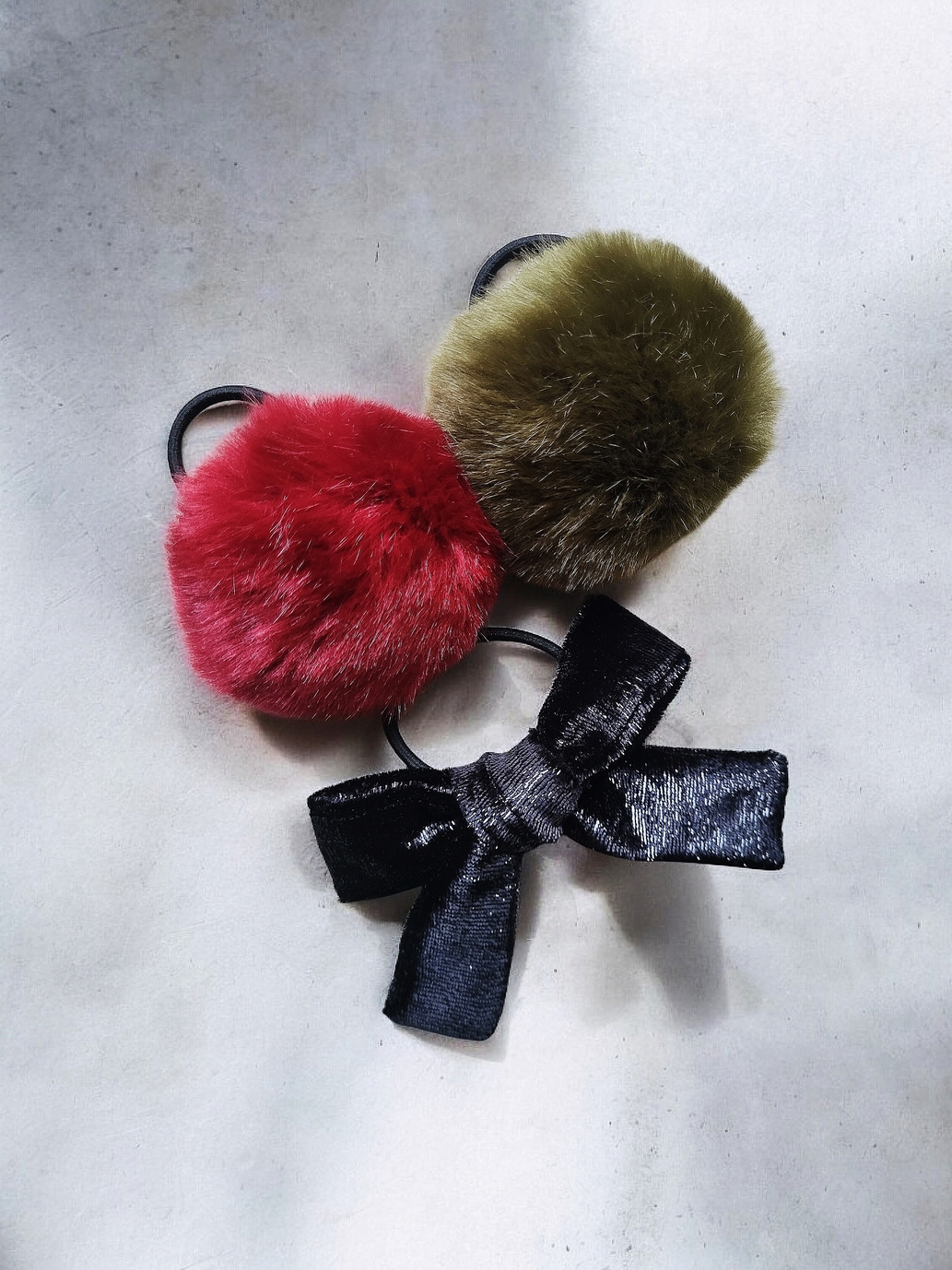Tili Studio Faux Fur Pom Pom Hair Bow Black Hair accessory set: Two colorful faux fur pom pom hair ties (dark red, green) and one black velvet bow with shimmer.